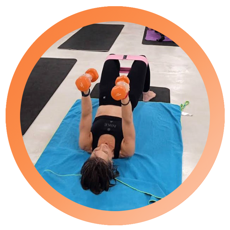 mujer en colchonetas tumbada con mancuernas