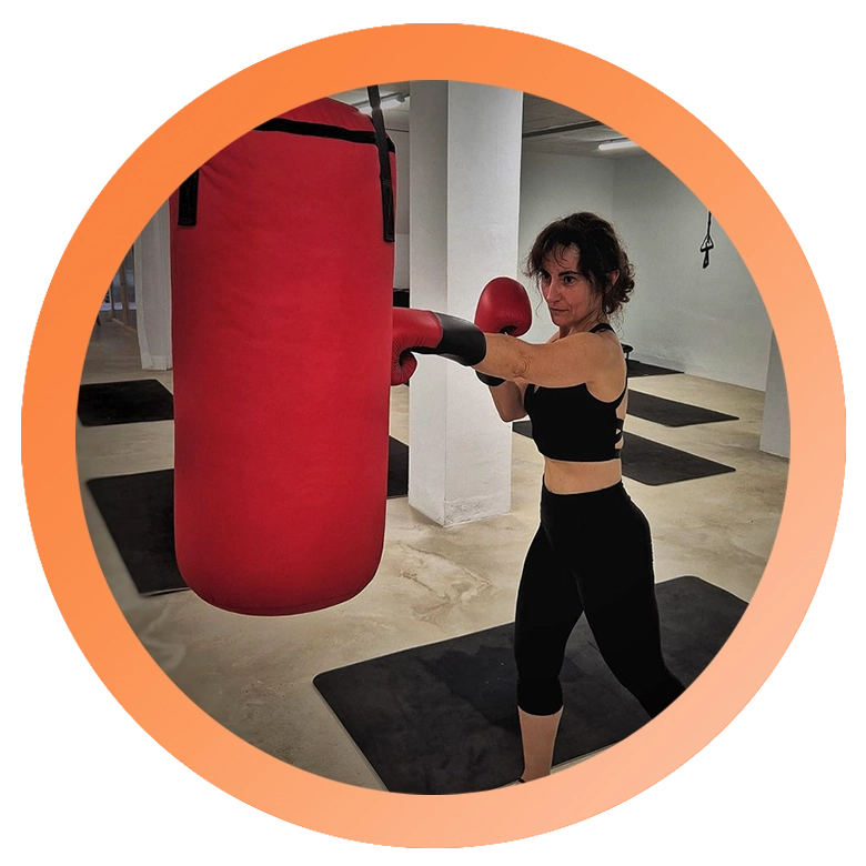 mujer con guantes golpeando saco